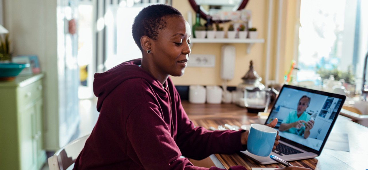 Close up of a young woman consulting with her doctor online on her laptop