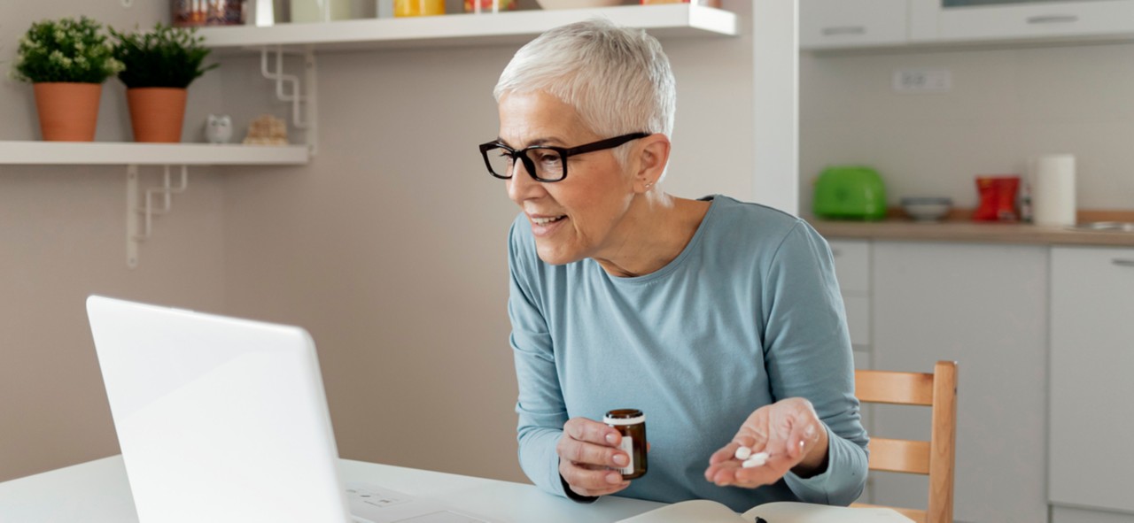 Senior Woman in Front of a Computer Monitor Talking With a Doctor Online Using Laptop to Inform About Medication Instructions. Concept of Telemedicine and Patient Counseling Online