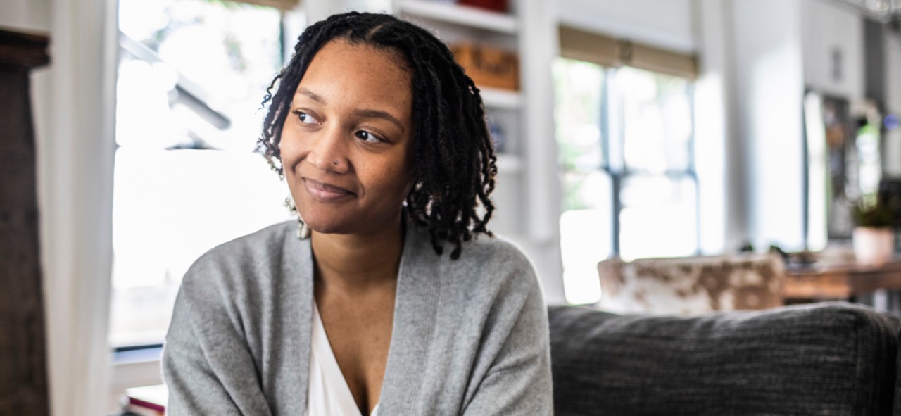 Woman holding smartphone on sofa at home