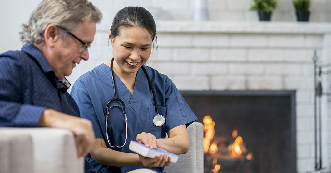 Medical professional consulting a patient at the patient's home.