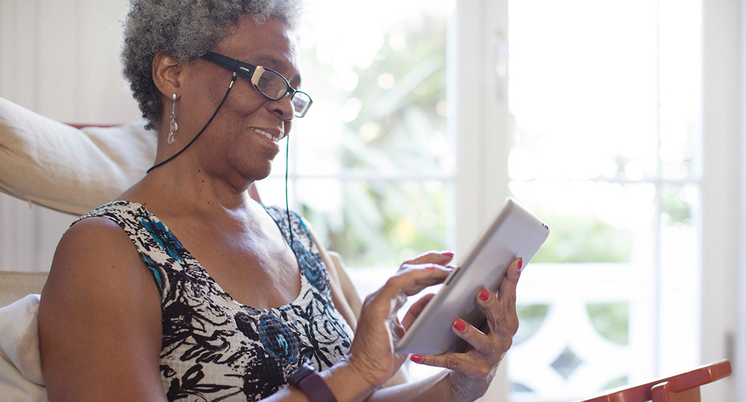 An older woman reading and learning about Medicare Part D enrollment