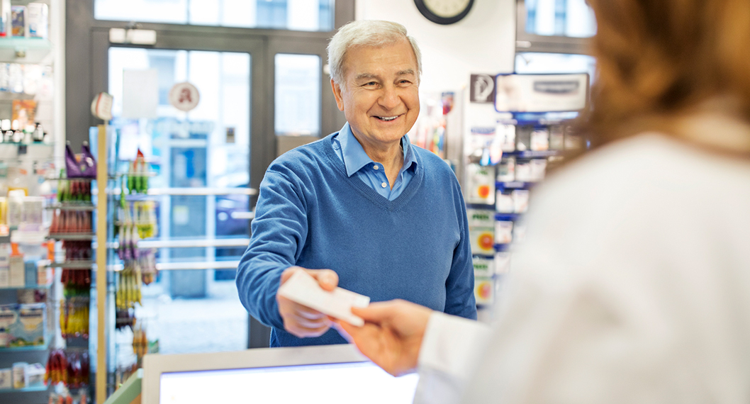 Senior man using Medicare Part D to get his prescription medicine at the pharmacy